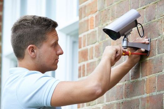 man fixing security camera